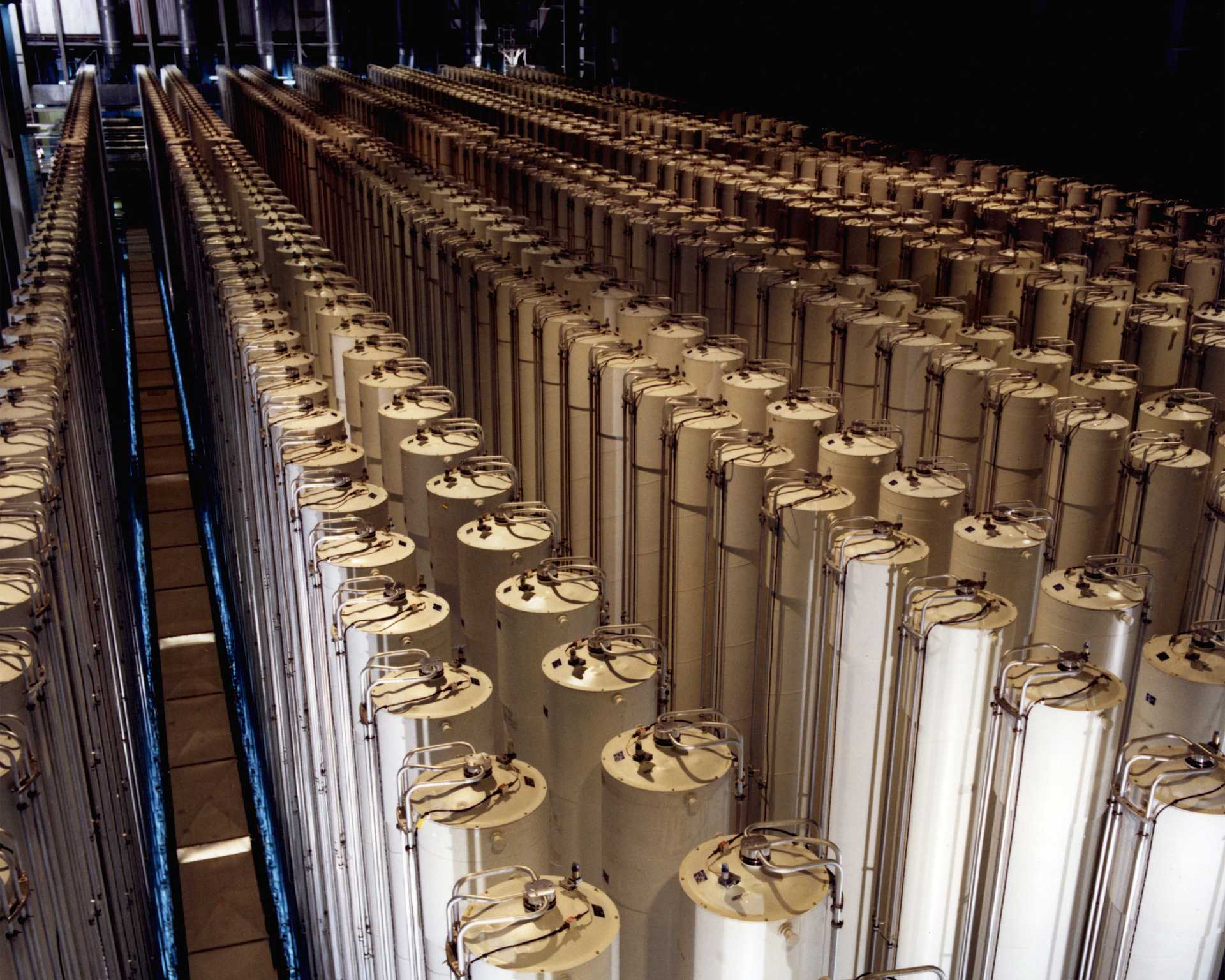 Rows of centrifuge machines in a dimly lit industrial facility.